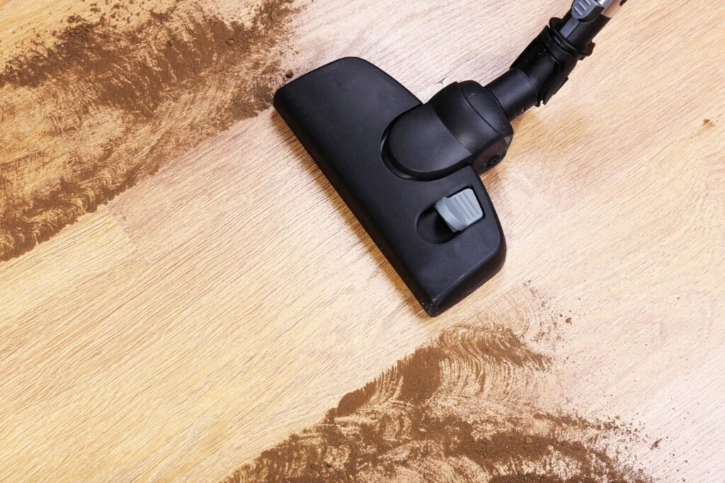 Vaccum Cleaner in the process of vacuuming dust and durbis from the hardwood floor